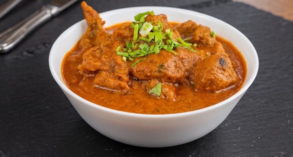 Bone-in chicken in a thick tomato gravy at Zaika by JJ, an Indian restaurant in Victoria, BC
