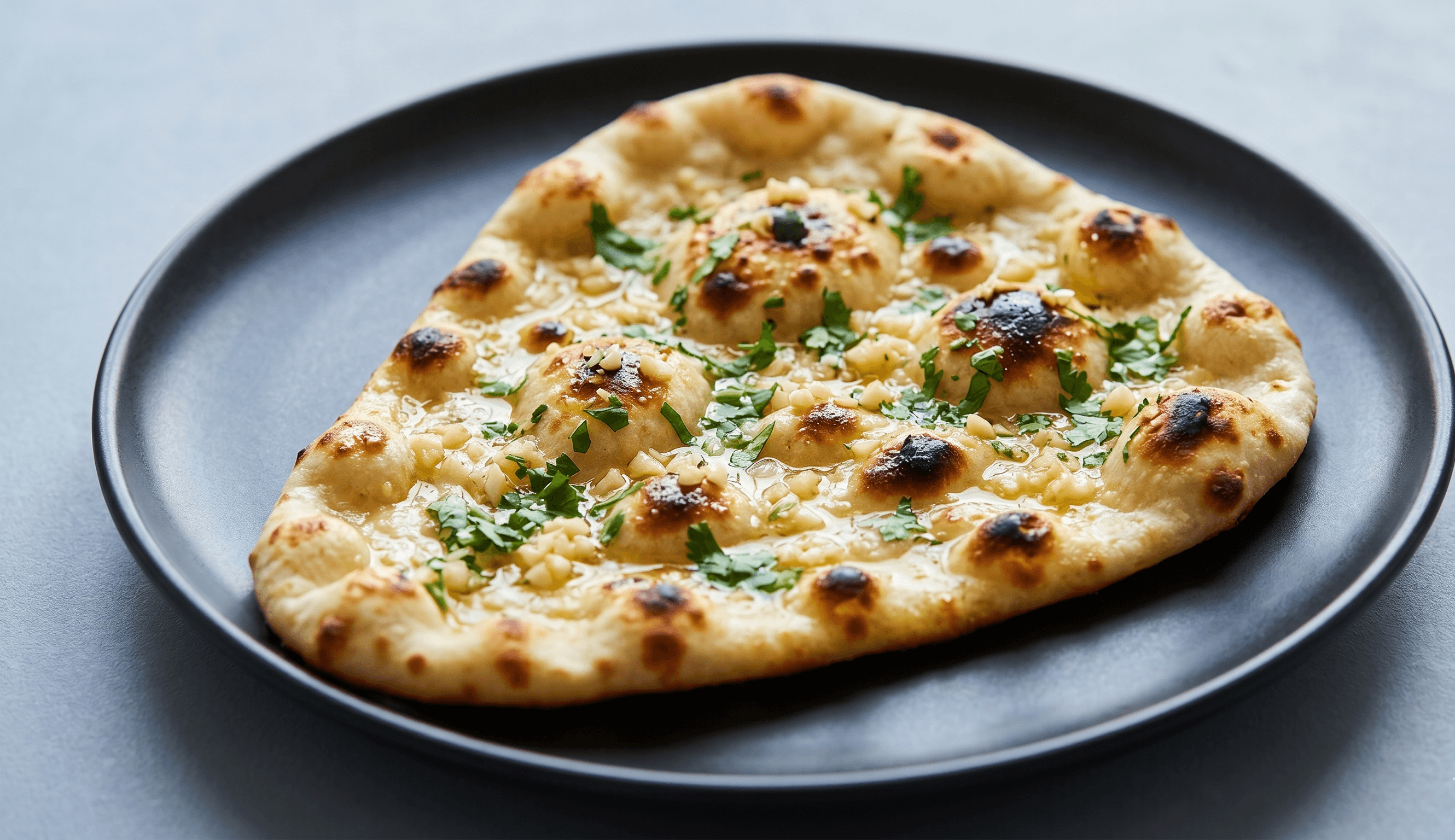 Fresh garlic naan baked in the tandoor and brushed with butter