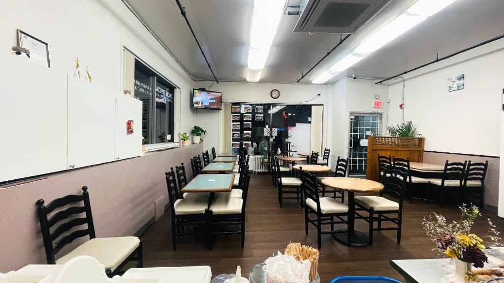 Zaika dining room with tables, chairs, and a view toward the kitchen and lunch specials